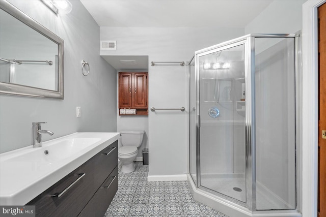 bathroom with vanity, a shower with shower door, and toilet