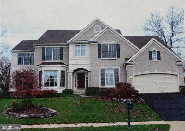 view of front of house with a garage and a front lawn