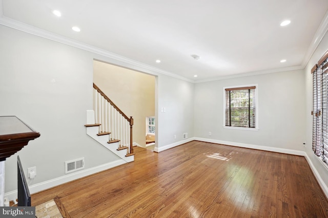 unfurnished living room featuring wood-type flooring and ornamental molding