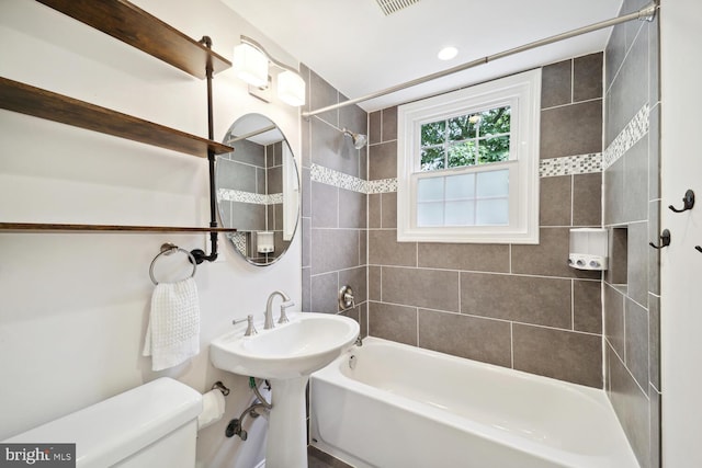 full bathroom with toilet, tiled shower / bath combo, and sink