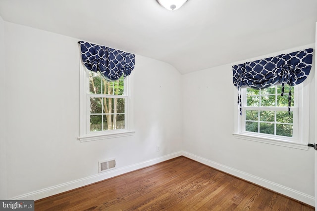 empty room featuring lofted ceiling and hardwood / wood-style floors