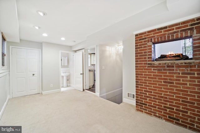 interior space with carpet floors, sink, connected bathroom, and a closet