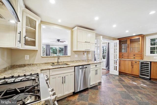 kitchen featuring white cabinets, light stone countertops, beverage cooler, and stainless steel appliances