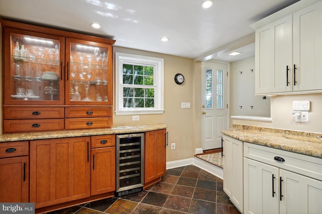 bar featuring white cabinets, beverage cooler, and light stone counters