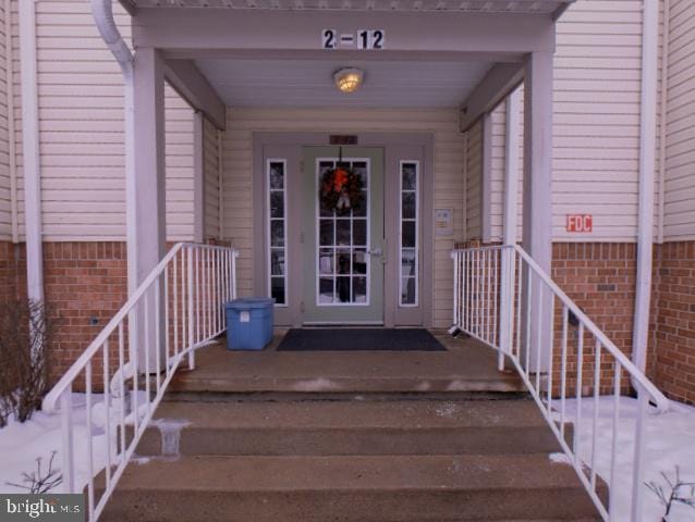 view of exterior entry with brick siding