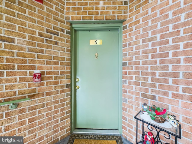 entrance to property featuring brick siding