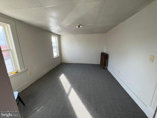 carpeted spare room with a paneled ceiling