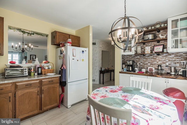 kitchen featuring an inviting chandelier, decorative light fixtures, and white refrigerator