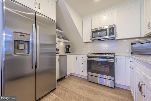 kitchen with decorative backsplash, white cabinets, stainless steel appliances, and light wood-type flooring