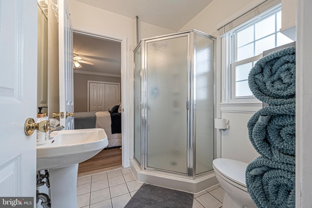 bathroom featuring tile patterned floors, crown molding, ceiling fan, toilet, and an enclosed shower