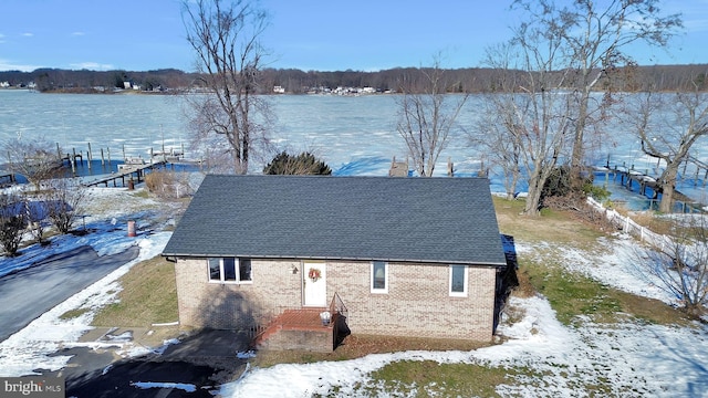 snowy aerial view featuring a water view