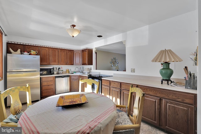 kitchen featuring kitchen peninsula, stainless steel appliances, and sink