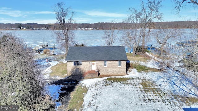 snowy aerial view featuring a water view