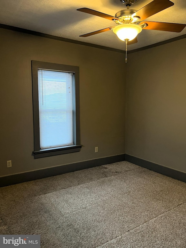 carpeted empty room with ceiling fan, a textured ceiling, and ornamental molding