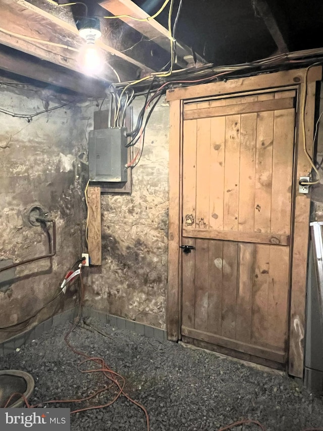 basement with electric panel and wooden walls