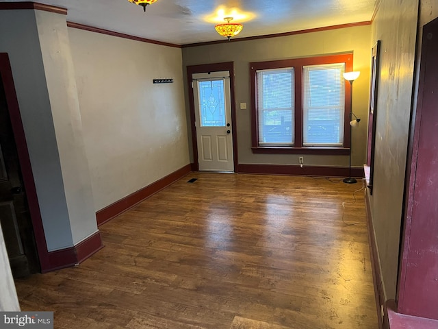 entrance foyer with ornamental molding and dark wood-type flooring