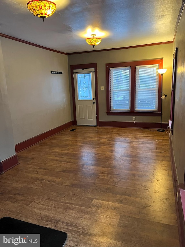 foyer entrance featuring crown molding and dark hardwood / wood-style flooring