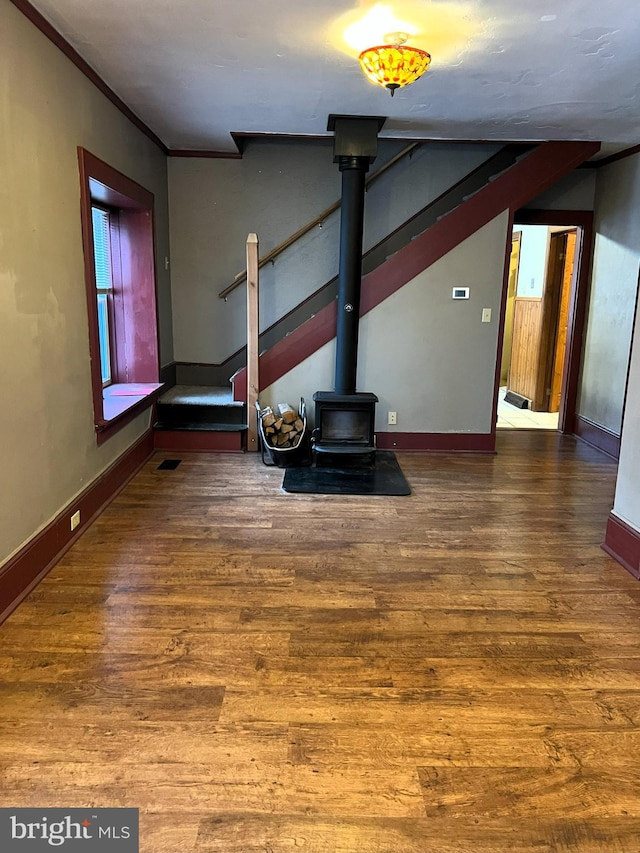 unfurnished living room with hardwood / wood-style floors and ornamental molding