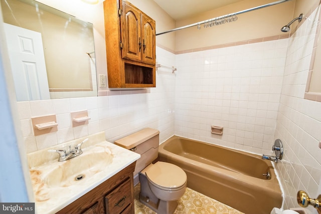 full bathroom featuring toilet, decorative backsplash, tile walls, tiled shower / bath, and vanity