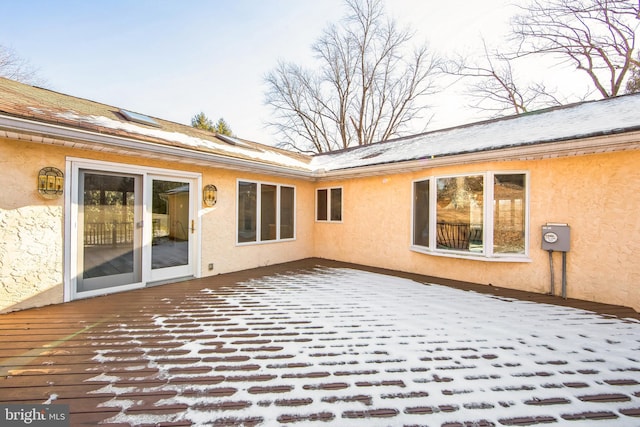 snow covered property featuring a wooden deck