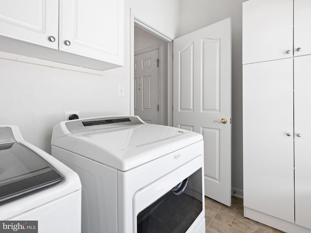 washroom with cabinets and washing machine and dryer