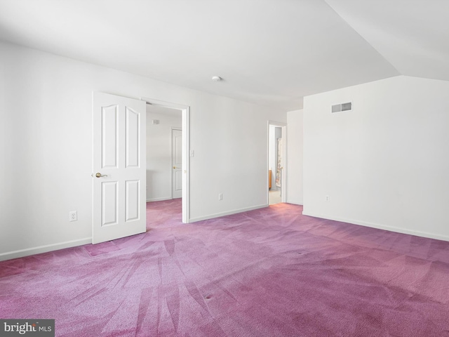 carpeted empty room with vaulted ceiling