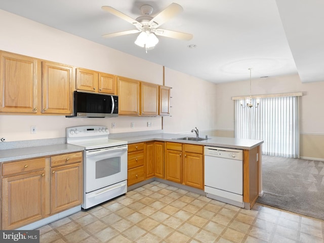 kitchen featuring kitchen peninsula, white appliances, ceiling fan with notable chandelier, sink, and pendant lighting