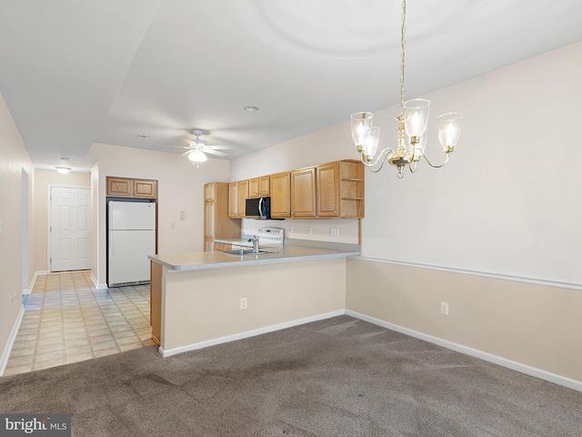 kitchen featuring ceiling fan with notable chandelier, white refrigerator, kitchen peninsula, and hanging light fixtures