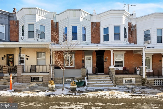 townhome / multi-family property with cooling unit and covered porch