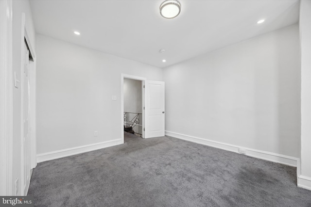 unfurnished bedroom with dark carpet