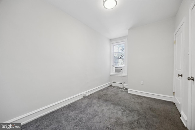 empty room featuring baseboard heating and dark colored carpet