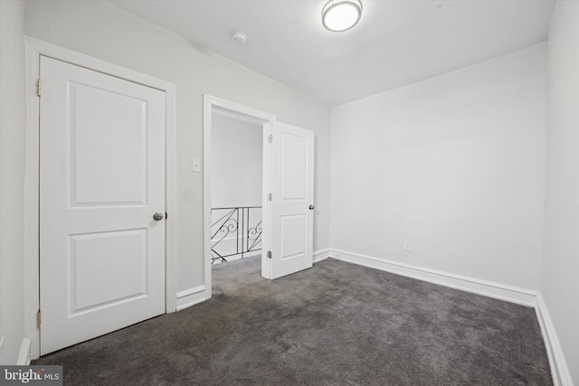 unfurnished bedroom featuring dark carpet