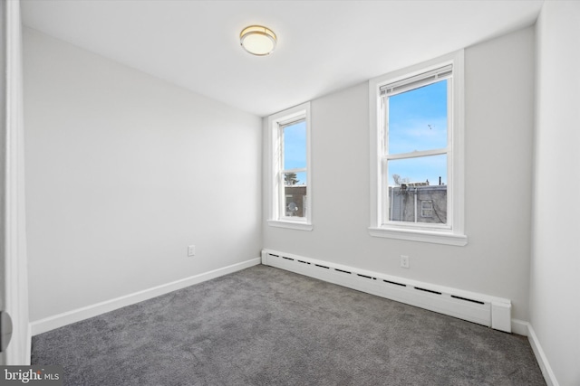 carpeted spare room featuring a baseboard heating unit