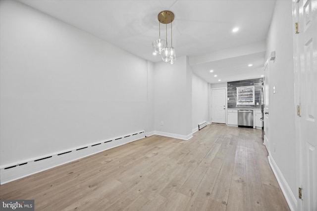 unfurnished dining area with a chandelier, light hardwood / wood-style flooring, and a baseboard heating unit