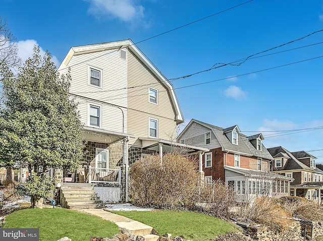 exterior space featuring covered porch and a front lawn