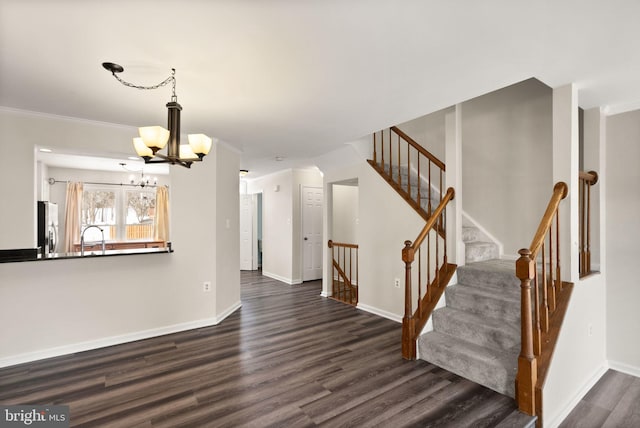 interior space with dark hardwood / wood-style flooring, crown molding, a notable chandelier, and sink