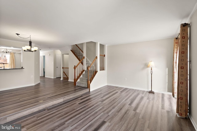 unfurnished living room featuring hardwood / wood-style floors, a chandelier, and ornamental molding