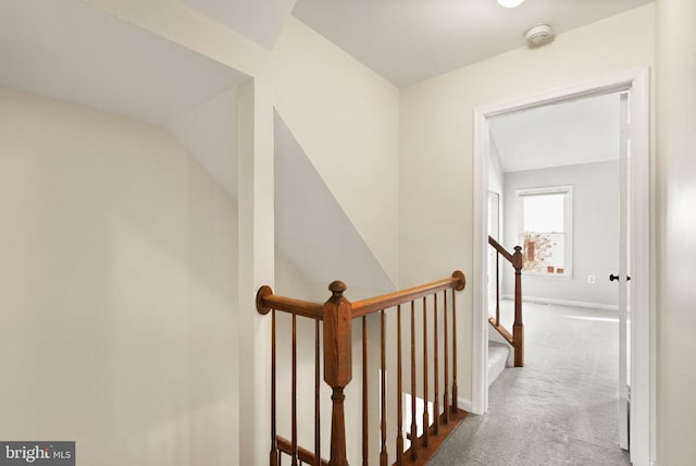 hallway featuring light carpet and vaulted ceiling