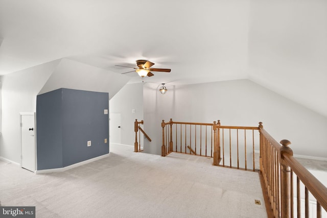 additional living space with ceiling fan, light colored carpet, and vaulted ceiling