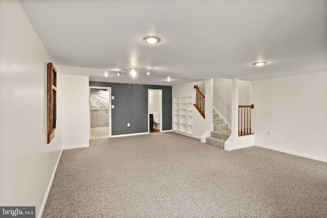 basement with carpet and track lighting