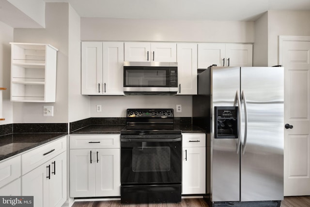 kitchen featuring dark hardwood / wood-style floors, dark stone countertops, white cabinetry, and appliances with stainless steel finishes