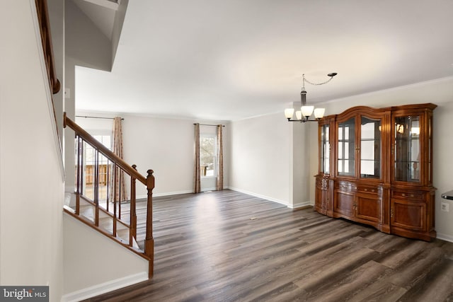 unfurnished dining area with a chandelier, ornamental molding, and dark wood-type flooring