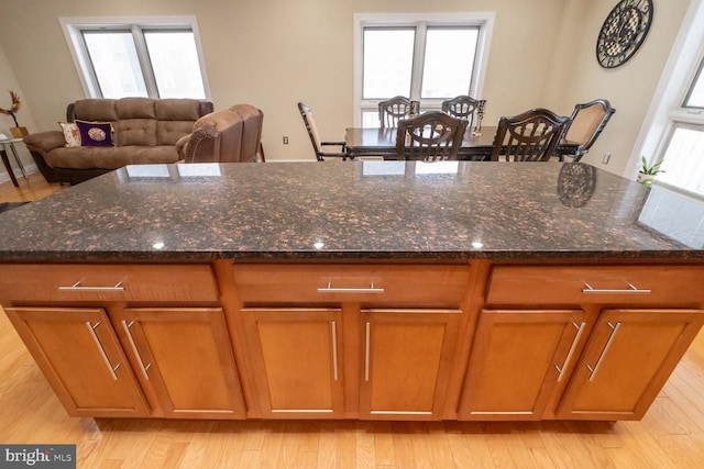 kitchen with light hardwood / wood-style flooring and dark stone counters