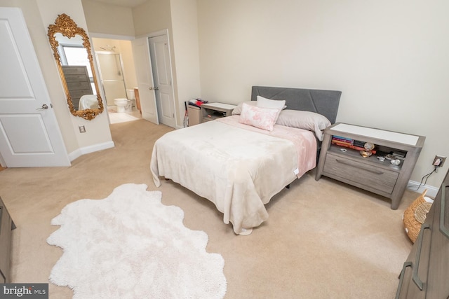 bedroom featuring light carpet and connected bathroom