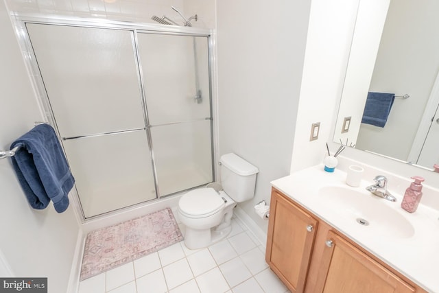 bathroom featuring tile patterned flooring, a shower with door, vanity, and toilet