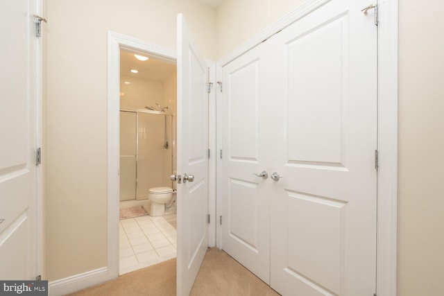 bathroom with toilet, tile patterned floors, and walk in shower