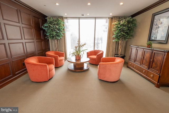 sitting room with crown molding, light carpet, and a wall of windows