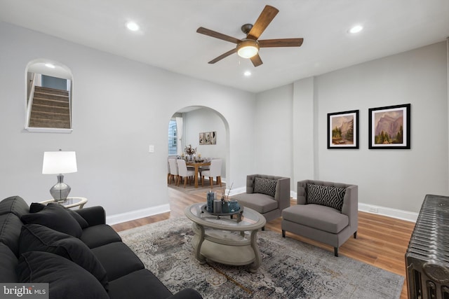 living room featuring ceiling fan and light hardwood / wood-style floors