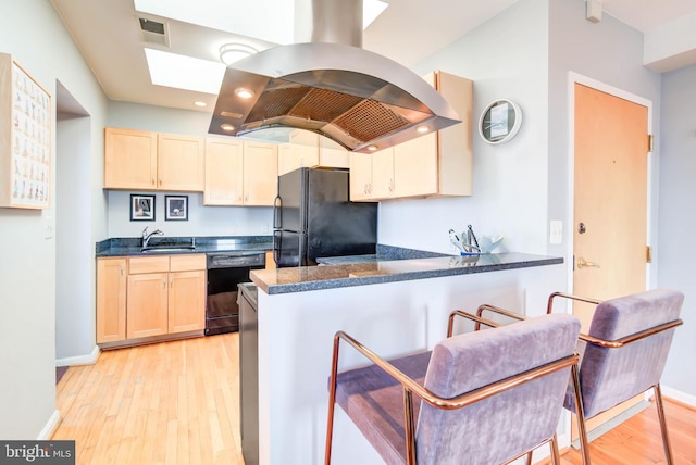 kitchen featuring visible vents, black appliances, light wood finished floors, dark countertops, and island exhaust hood