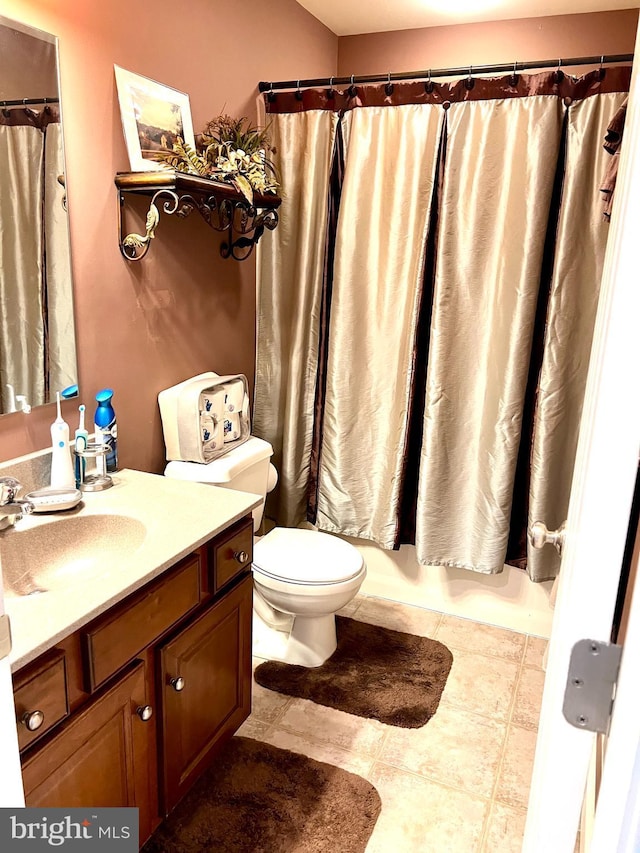 bathroom featuring tile patterned flooring, vanity, and toilet